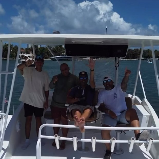 Guests standing in the covered cockpit with their arms up, waving at the camera